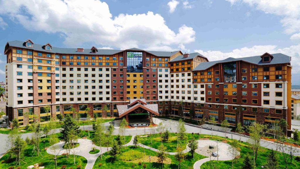 a large building with a park in front of it at Holiday Inn Express Changbaishan, an IHG Hotel in Fusong