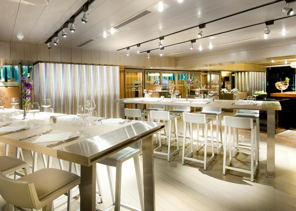 a restaurant with white tables and white chairs at The Marmara Taksim in Istanbul