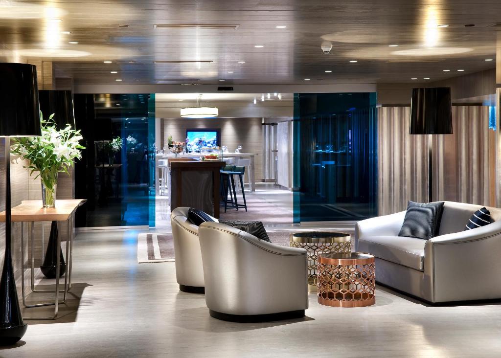 a lobby with chairs and a bar in the background at The Marmara Taksim in Istanbul