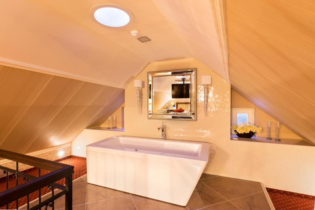 a bathroom with a large white tub in a room at Hotel Dvorana in Karlovy Vary