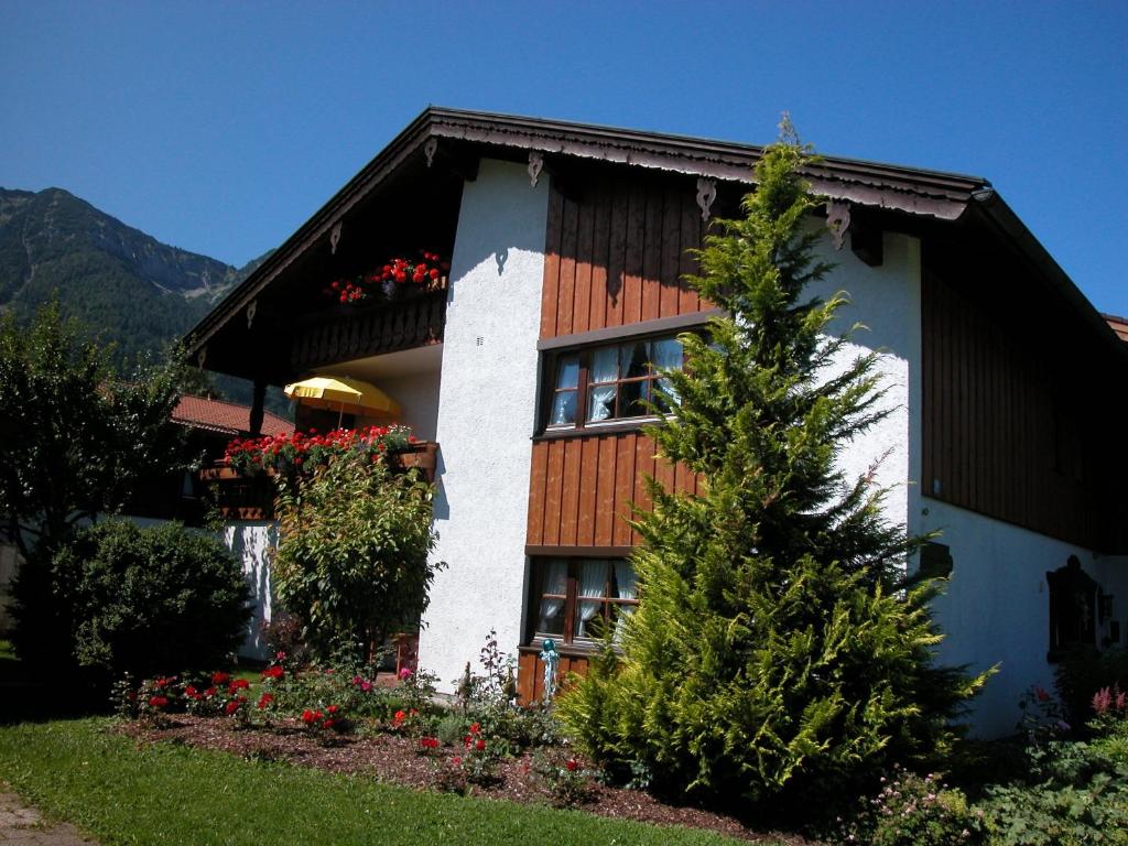 a house with a tree in front of it at Ferienwohnungen Kirmse in Inzell