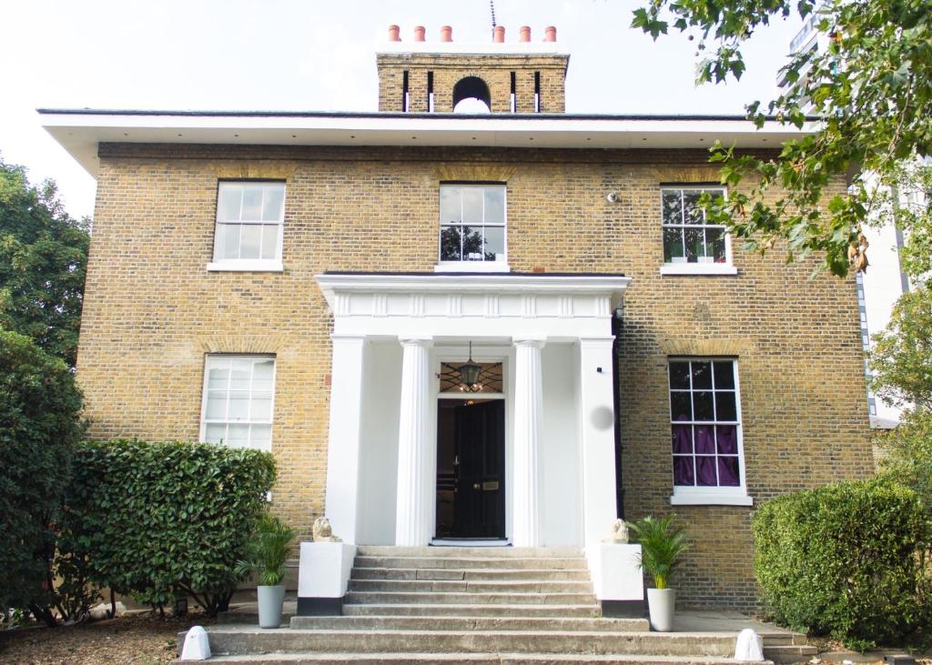 an old brick building with a white front door at Larger Groups Apartment close to Excel CanaryWharf 02 with Parking in London