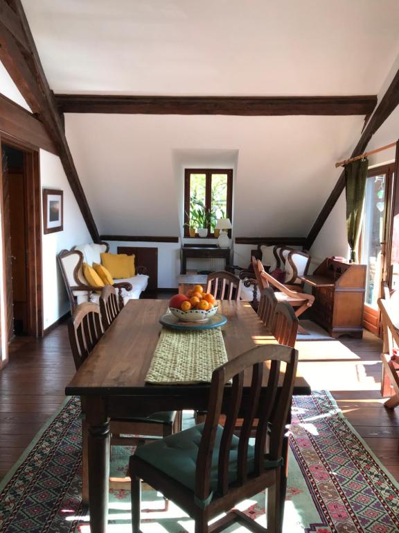 uma sala de jantar com uma mesa de madeira e cadeiras em Castle View Menthon em Menthon-Saint-Bernard