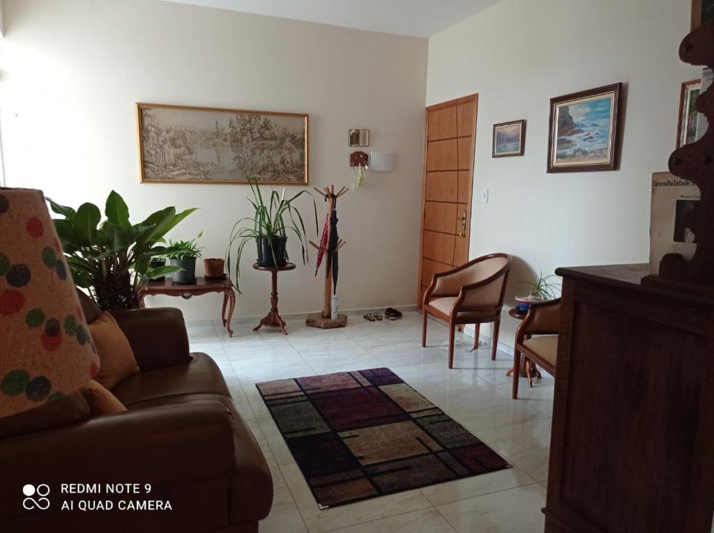 een woonkamer met een bank en een tafel en stoelen bij Cunha centro - quarto cama de casal in Cunha