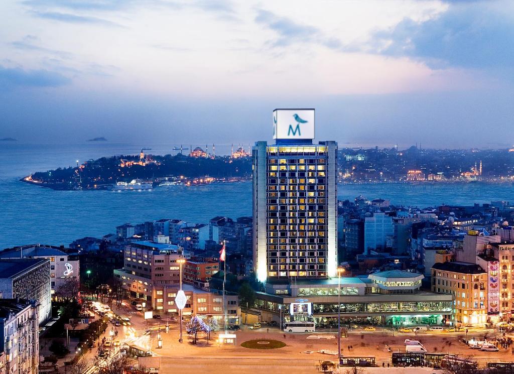 a tall building with a sign on top of it at The Marmara Taksim in Istanbul