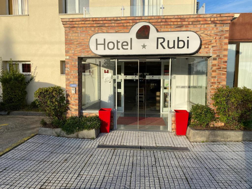 un edificio con una señal de hotel doblada delante de él en Hotel Rubi en Viseu