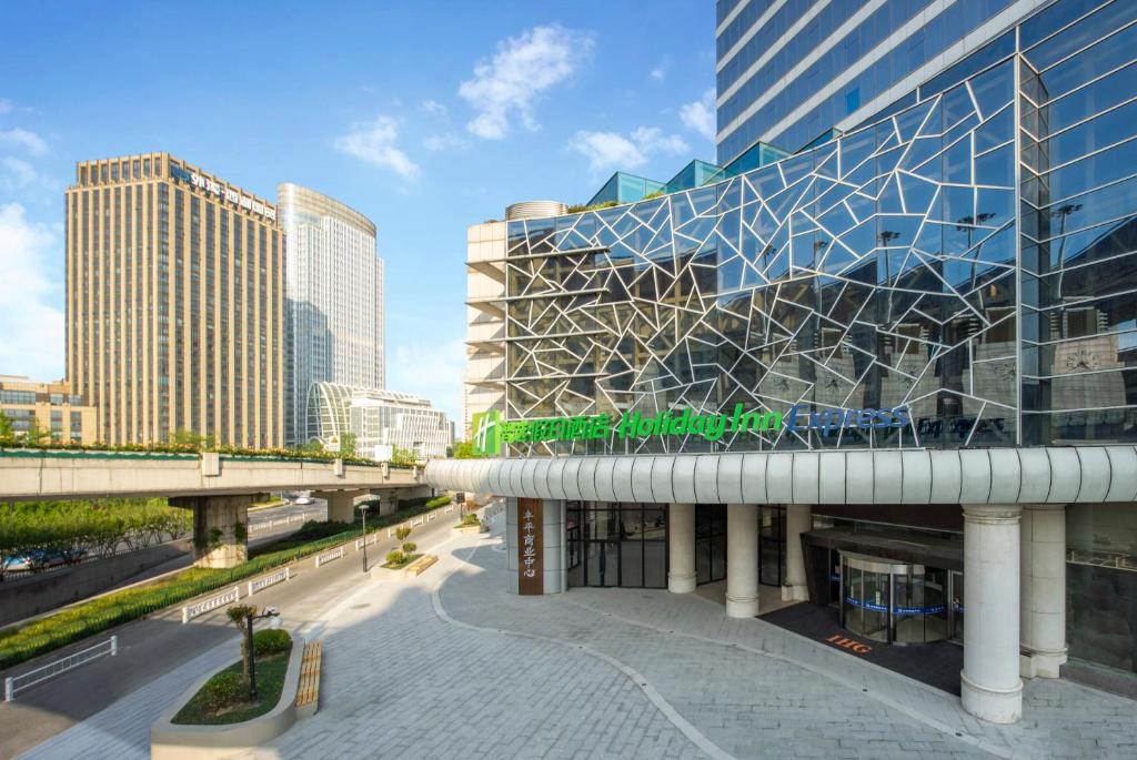 Holiday Inn Express Hangzhou Westlake East, an IHG Hotel في هانغتشو: اطلالة على مبنى في مدينة ذات مباني طويلة