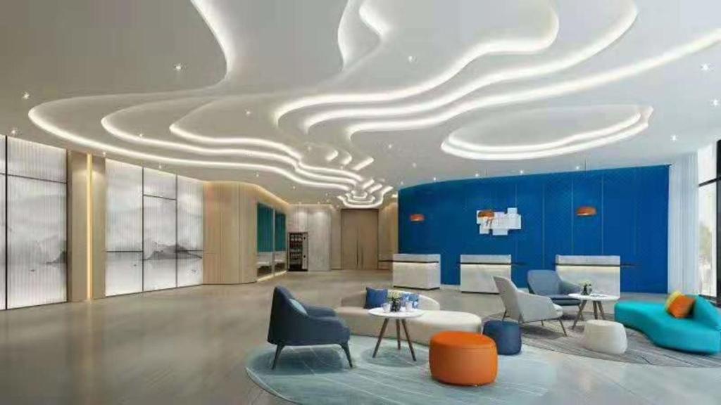 a lobby with a blue and white ceiling with chairs and tables at Holiday Inn Express Linyi West, an IHG Hotel in Linyi