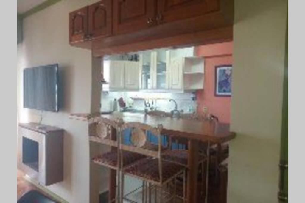 a kitchen with white cabinets and a counter top at Edificio Céntrico. in Colonia del Sacramento