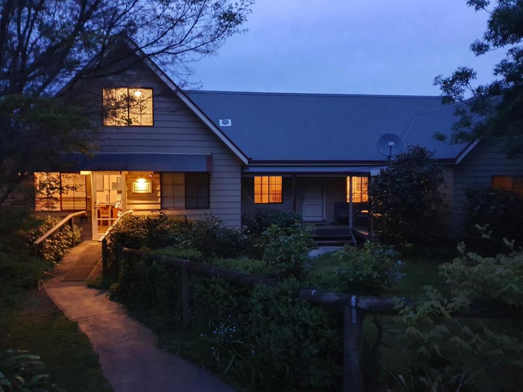 a house with its lights on in the evening at Neerim Country Cottages in Neerim South