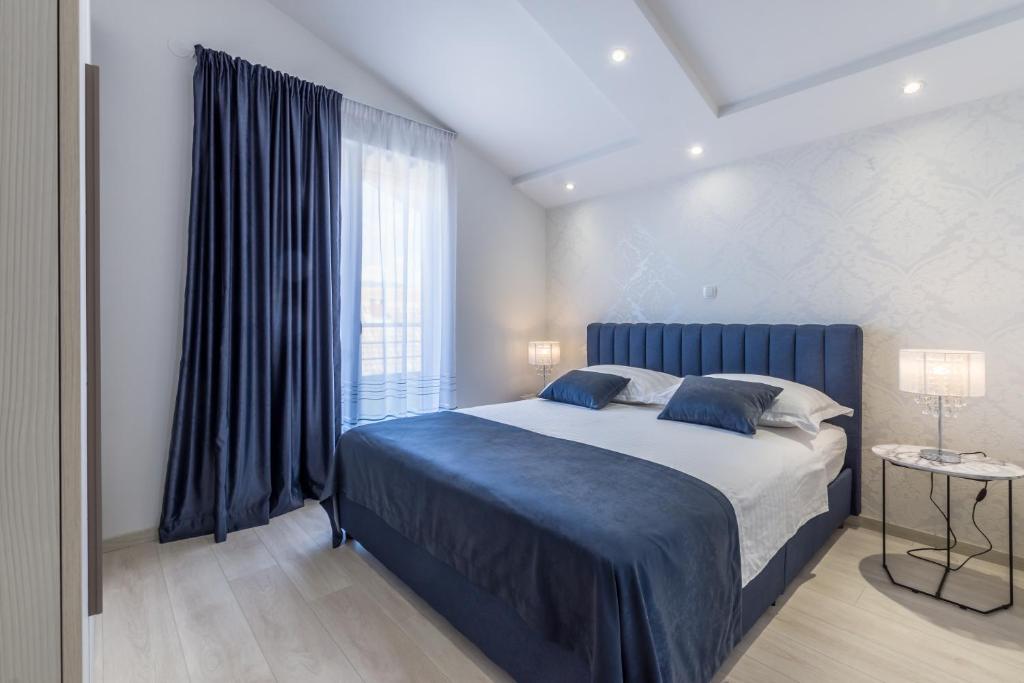 sypialnia z dużym łóżkiem i oknem w obiekcie Apartments Prestige w mieście Kaštela