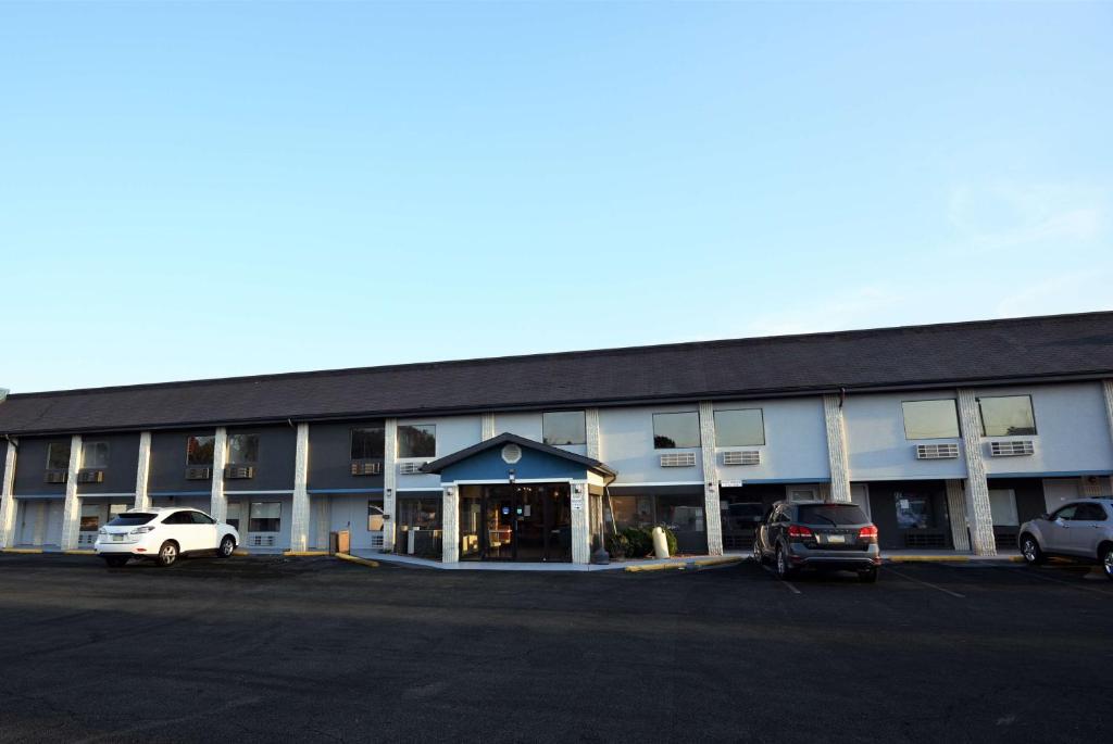 un gran edificio con coches estacionados en un estacionamiento en Baymont by Wyndham Pine Grove, en Pine Grove