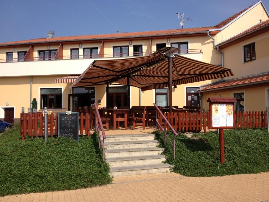 een gebouw met een restaurant met een trap en een paraplu bij Active Wellness hotel U zlaté rybky in Vyškov