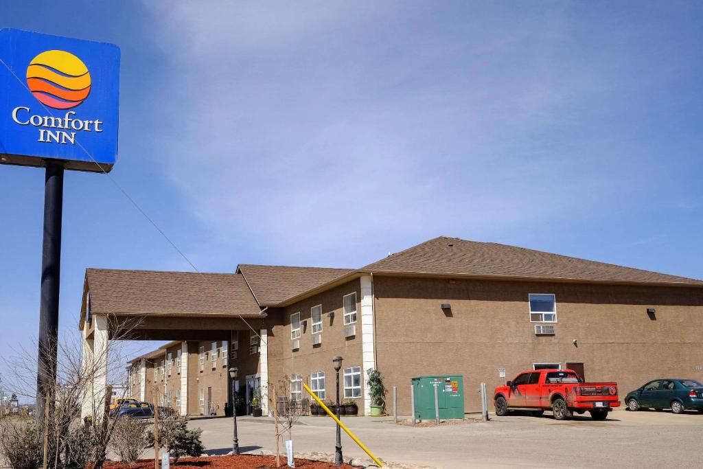 a building with a red truck parked in front of it at Comfort Inn in Dawson Creek