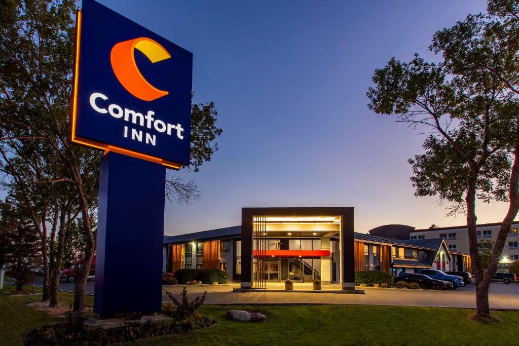 a sign in front of a building with ainion inn at Comfort Inn Airport in Winnipeg