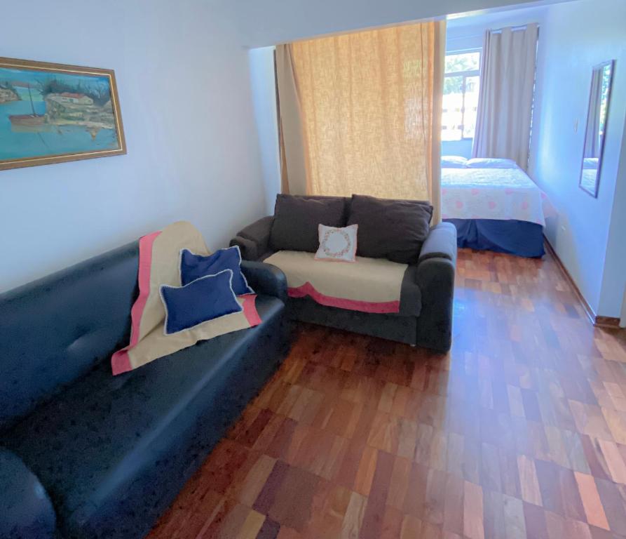 een woonkamer met een bank en een bed bij Estúdio/Apartamento praia de São Vicente in São Vicente