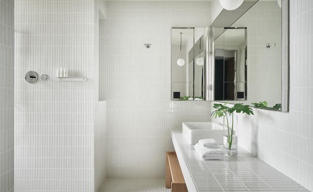 a white bathroom with a sink and a mirror at Kimpton Da An Taipei- an IHG Hotel in Taipei