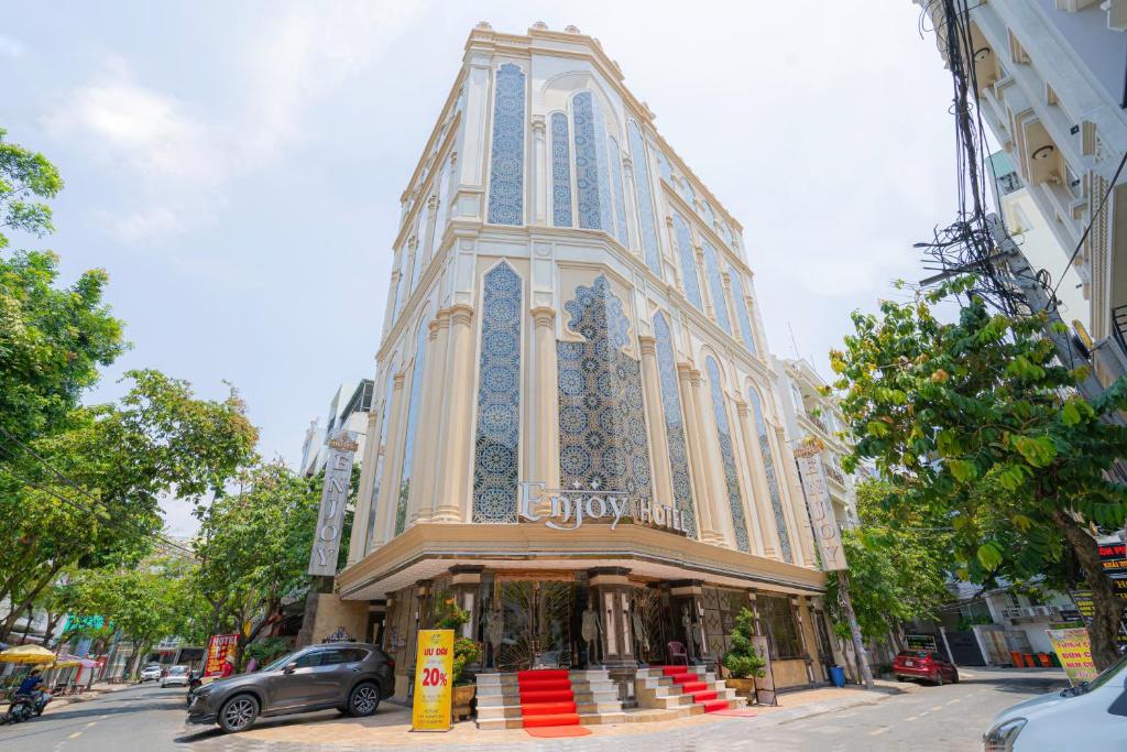 een gebouw in een straat met een auto voor de deur bij Enjoy Hotel 5A in Ho Chi Minh-stad