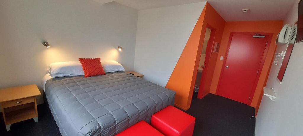 納爾遜的住宿－YHA Nelson，小房间,配有床和红色凳子