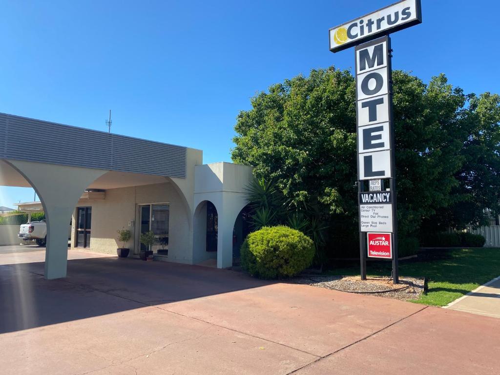 a sign in front of a building with a motel at Citrus Motel in Griffith