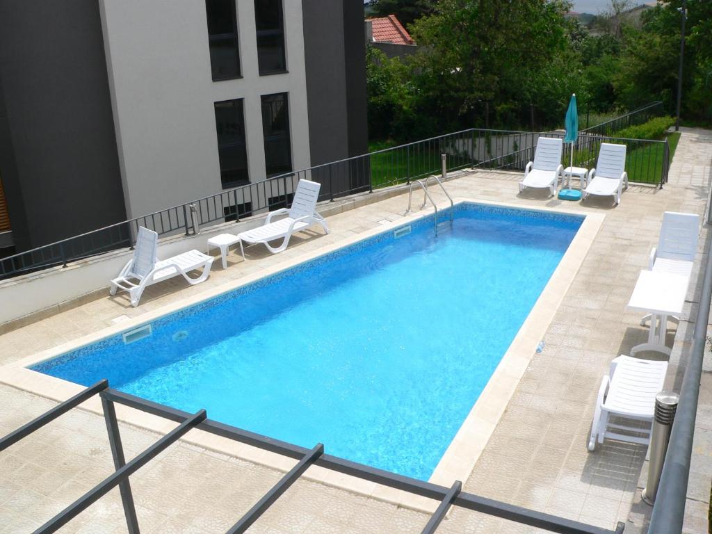 a large swimming pool with chairs at Boutique Home Apartments in Varna City