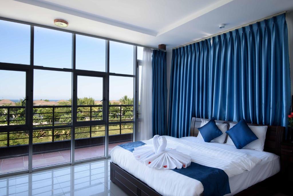 1 dormitorio con cama y ventana grande en Tehana Beach Hotel Da Nang, en Da Nang