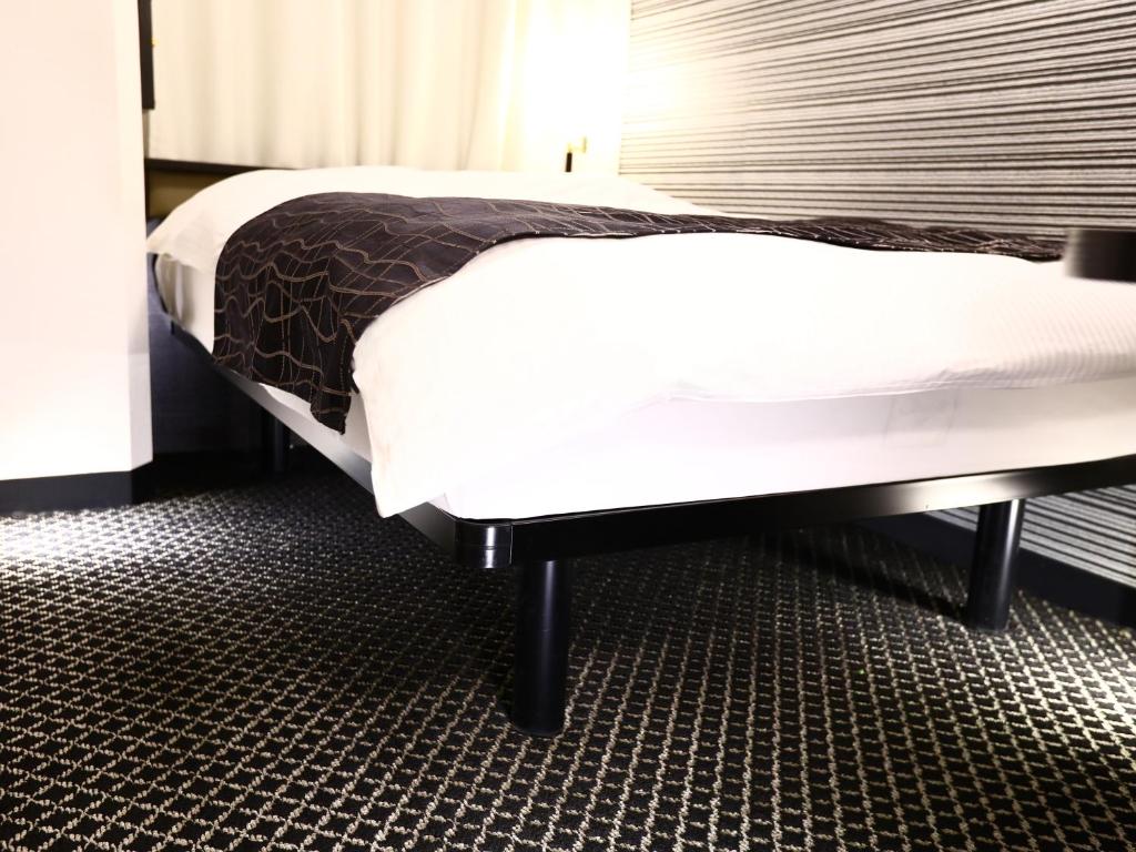 Postel nebo postele na pokoji v ubytování APA Hotel Shin Osaka Minamikata Ekimae