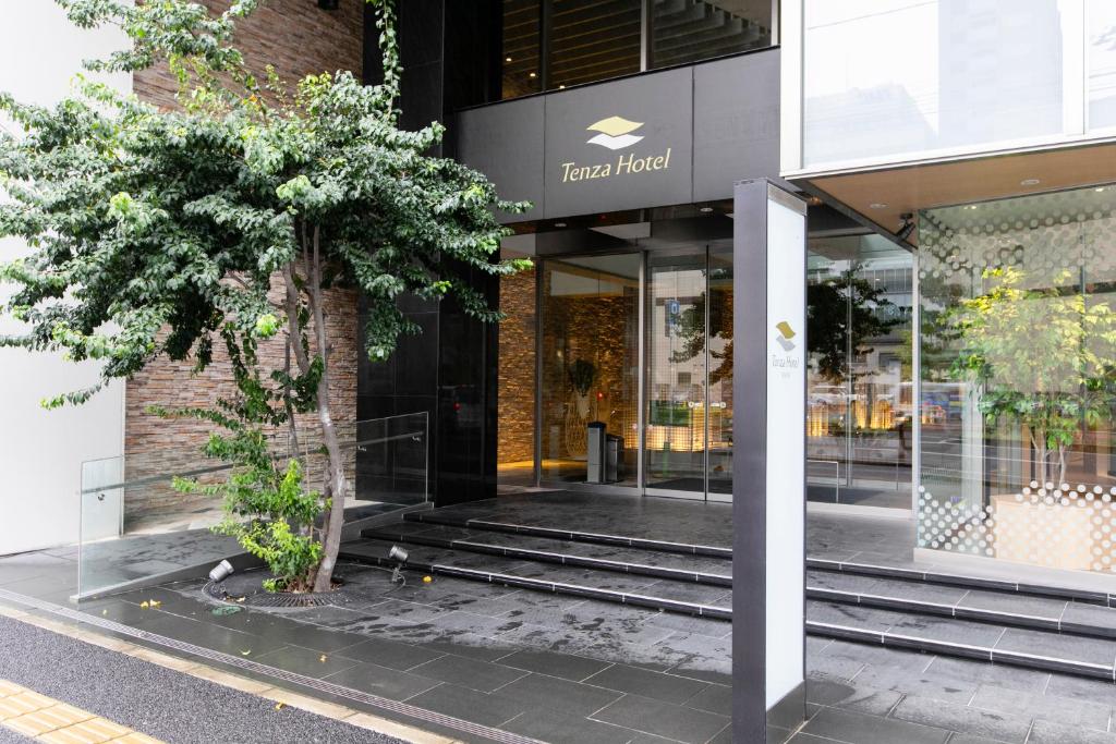 a store front with a tree in front of it at Tenza Hotel at Sendai Station in Sendai