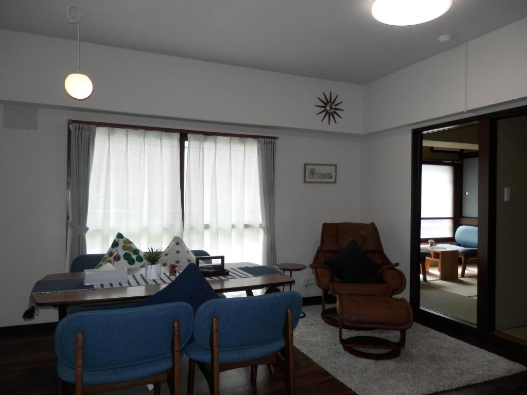 uma sala de estar com mesa e cadeiras em Maple Sumikawa #201 em Sapporo