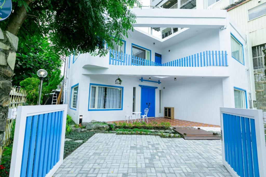 a white house with blue doors and a driveway at You Yue B&B in Hualien City