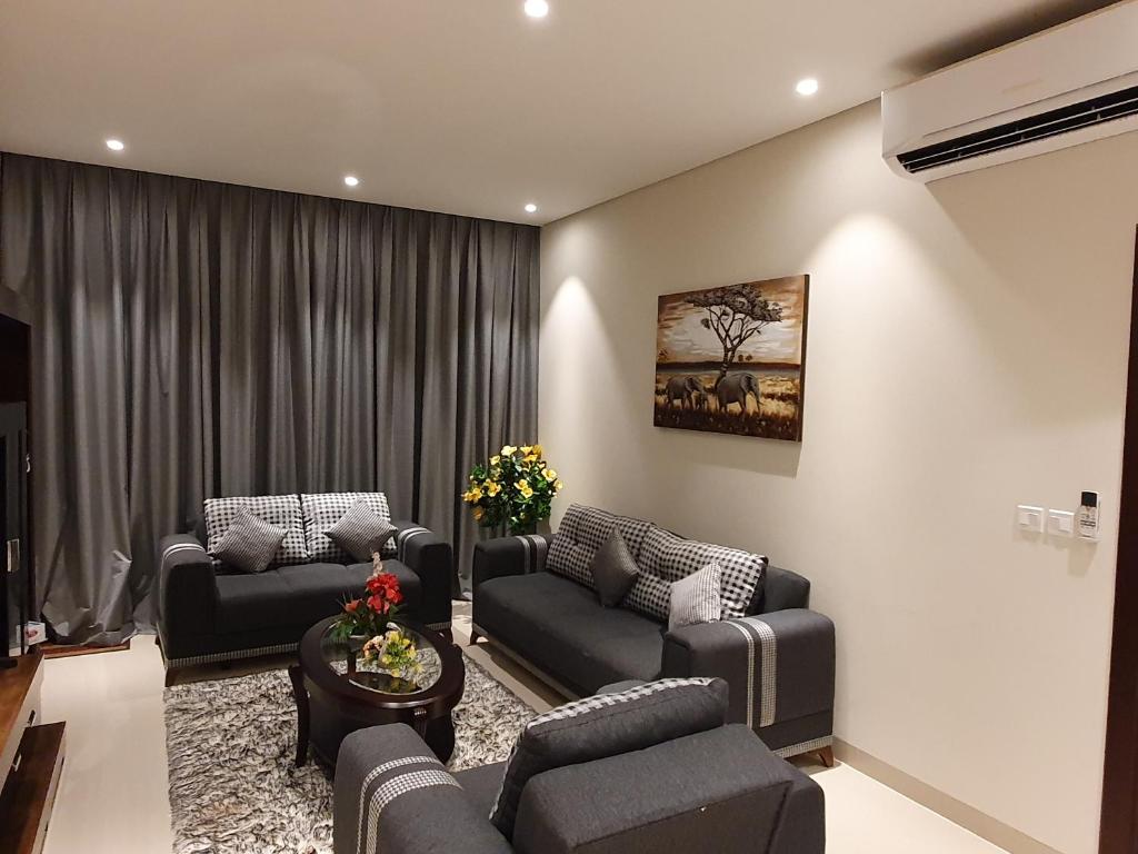 ein Wohnzimmer mit 2 Sofas und einem Tisch in der Unterkunft Lovely Apartment in Jebel Sifah with private Garden - As sifah in Muscat
