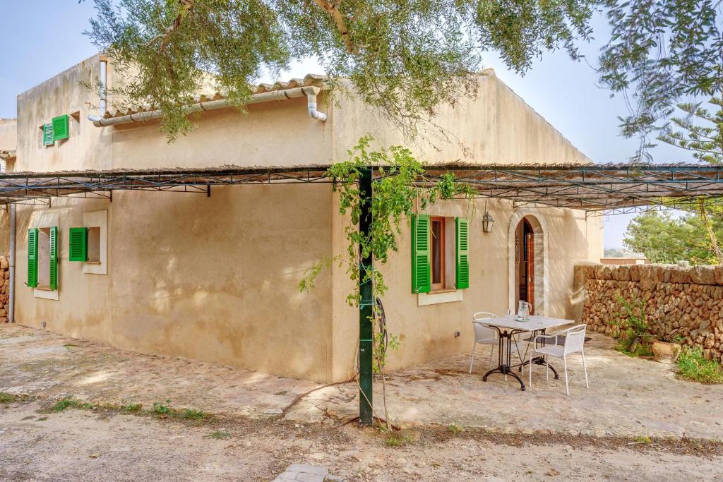 an old house with a table in front of it at Possessio Sa Barrala Casa del Pages in Campos