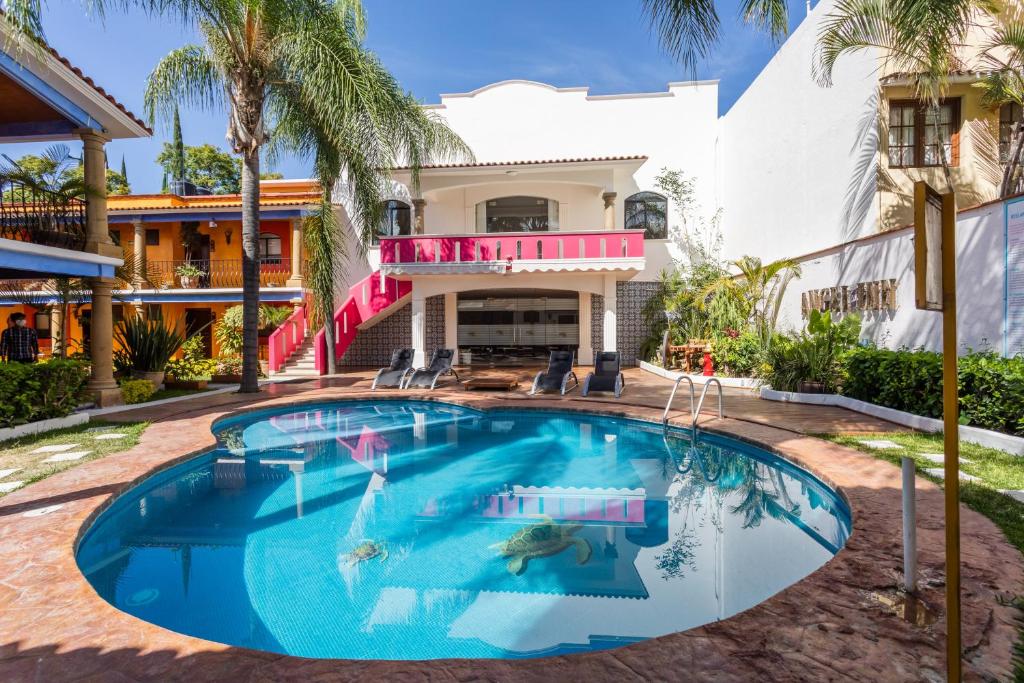 a swimming pool in front of a house at Hotel Ángel Inn in Oaxaca City