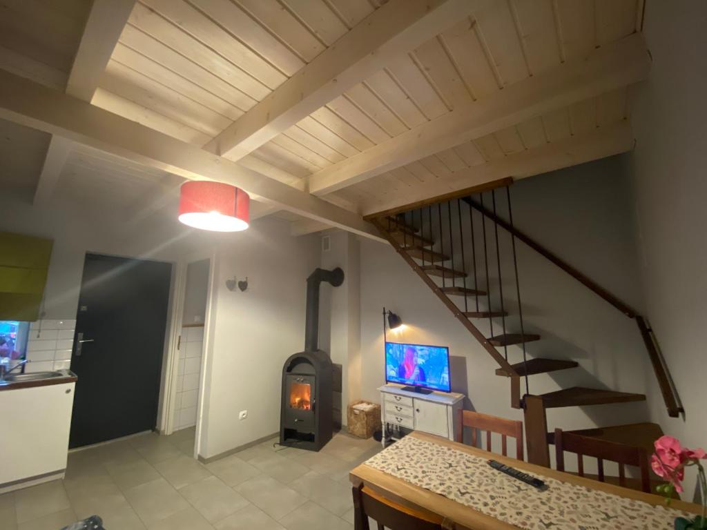 een woonkamer met een houtkachel en een trap bij Domek na Leśnej in Pogorzelica