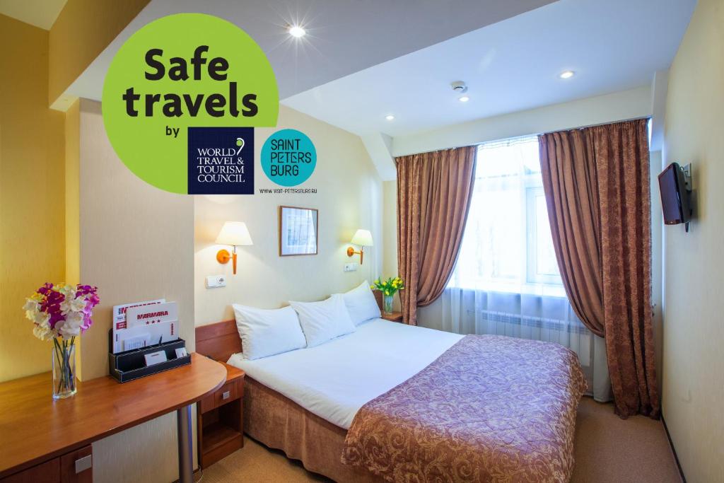 a hotel room with a bed and a sign that says safe travels at Marmara Hotel in Saint Petersburg