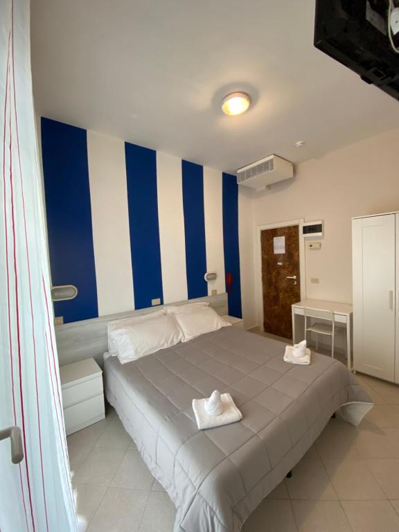een slaapkamer met een groot bed met blauwe en witte strepen bij Family Hotel Las Vegas in Riccione