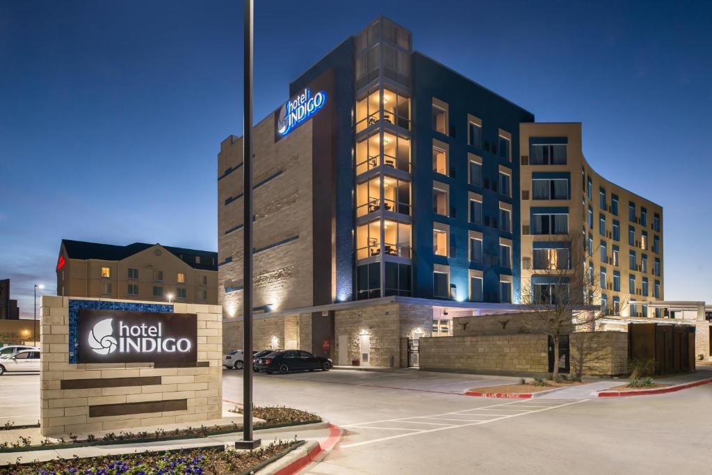 een hotel sindo-gebouw met een bord op een parkeerplaats bij Hotel Indigo - Frisco, an IHG Hotel in Frisco