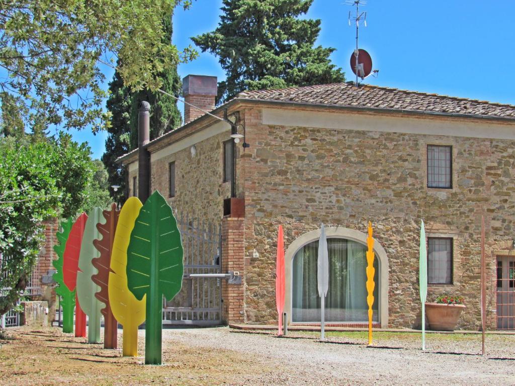 un edificio con banderas coloridas delante de él en La RIMESSA EXPERIENCE, en Montaione