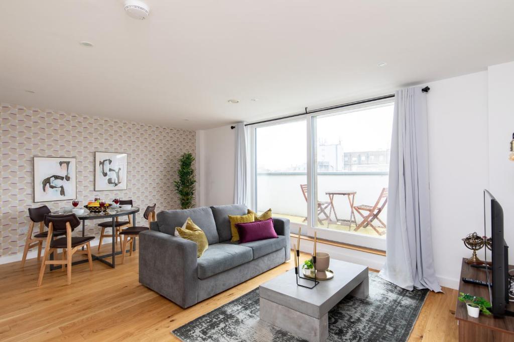 a living room with a couch and a table at homely – Central London Luxury Apartments Camden in London