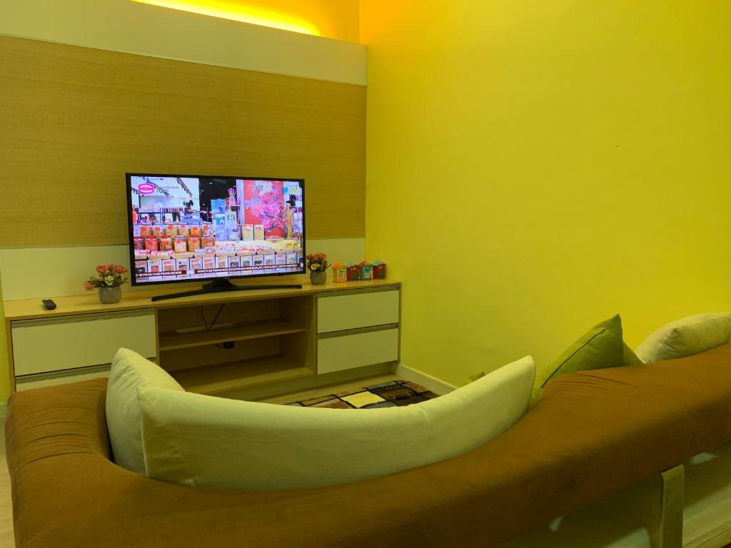 a living room with a couch and a flat screen tv at Woodsbury homestay Studio 57 Butterworth in Butterworth