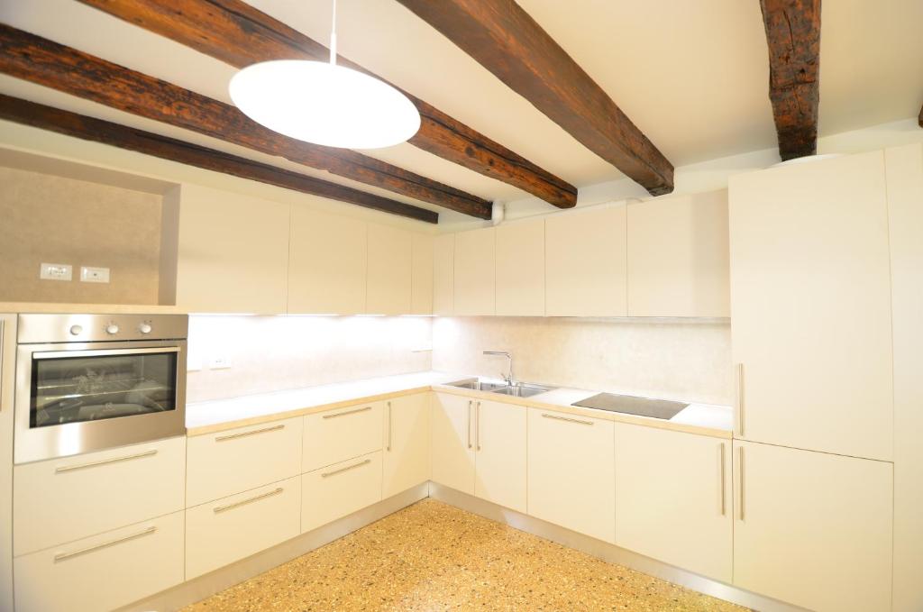 a kitchen with white cabinets and a ceiling at Dimora Frari, vicino Campo Santa Margherita in Venice