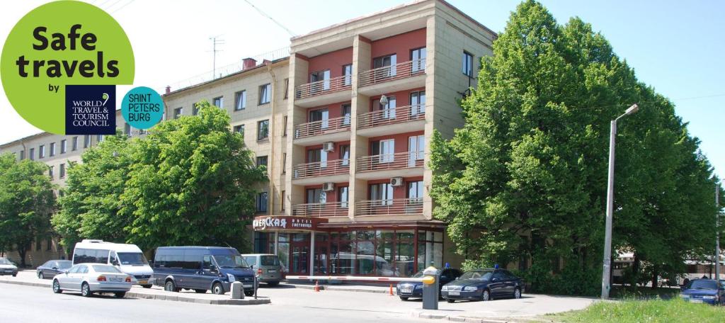 a building with cars parked in front of a street at Kievskaya Hotel in Saint Petersburg