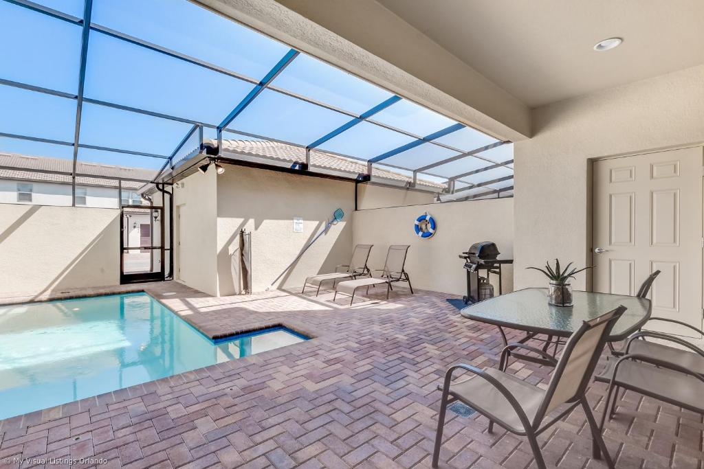 a room with a pool and a table and chairs at Resort Townhome wPRIVATE Pool & BBQ, near Disney in Kissimmee