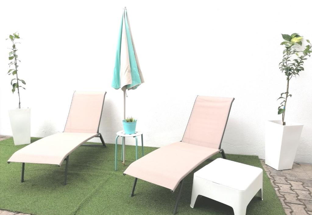 3 Stühle und ein Tisch mit einer Flagge in der Unterkunft Apartamento * Estudio Orobanca in Santa Brígida