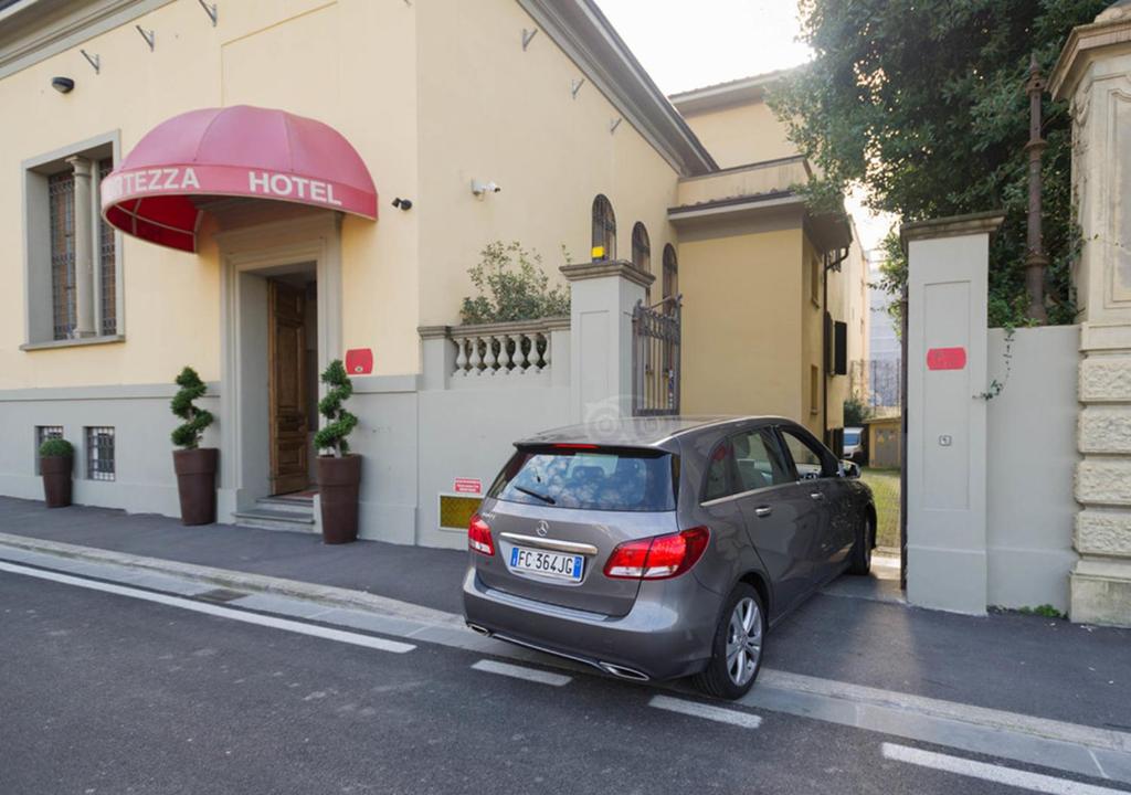 un pequeño coche aparcado frente a un hotel en Hotel La Fortezza en Florencia