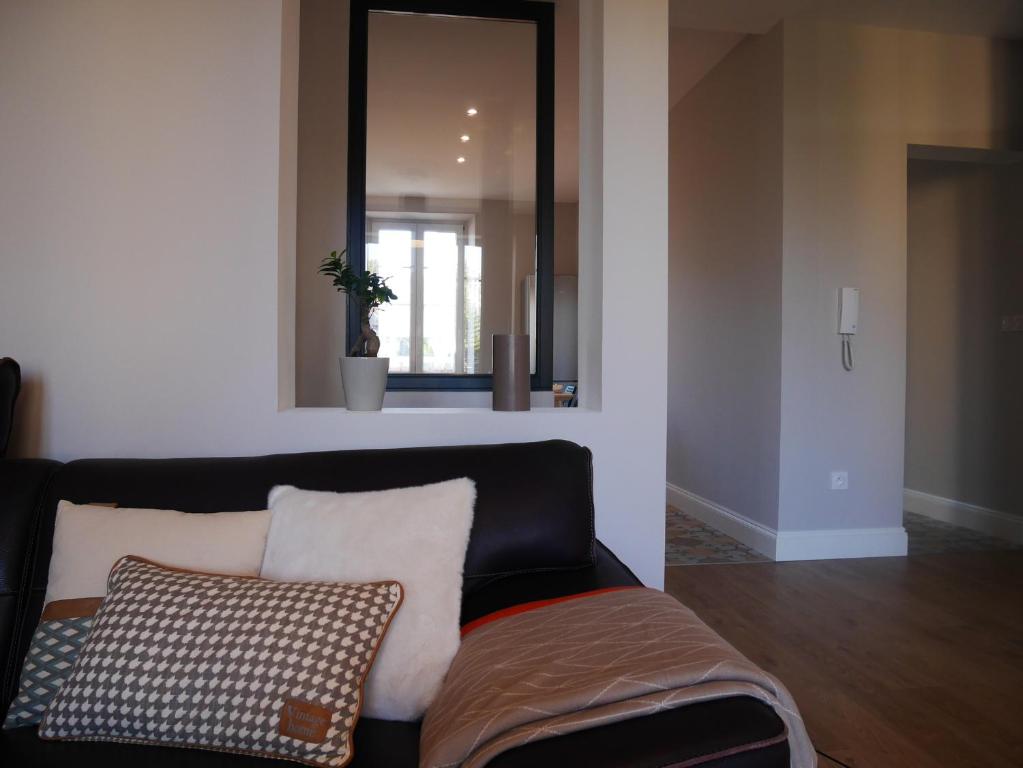 ein Wohnzimmer mit einem Sofa und einem Spiegel in der Unterkunft Cosy Home Colmar - Petite Venise in Colmar