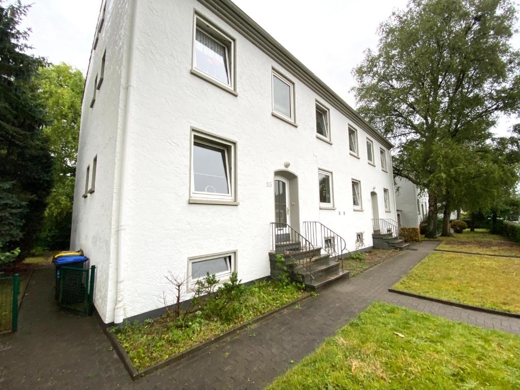 a large white building with stairs and a yard at Ruhige 3-Zimmerwohnung im Norden Bremens für Monteure und Geschäftsreisende in Bremen