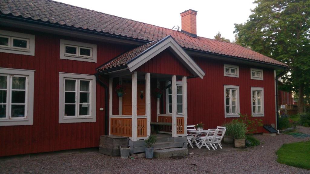 a red house with a table and chairs in front of it at Röda stugan in Hedemora