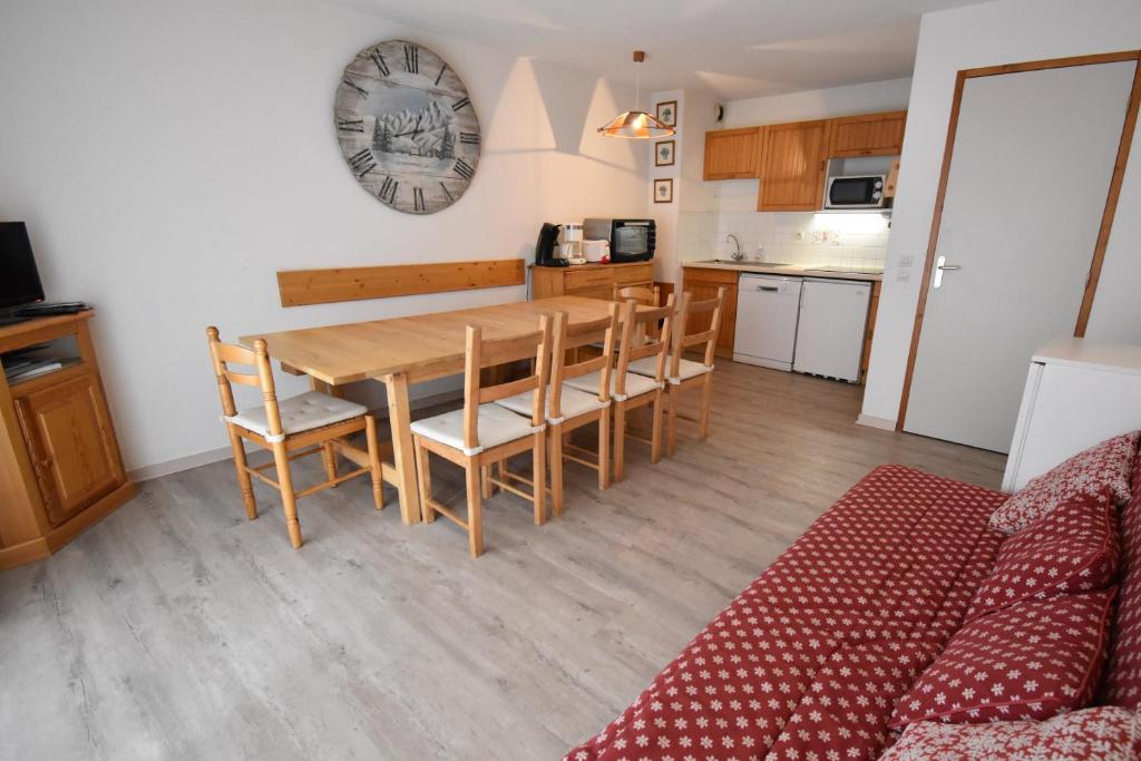 une cuisine et une salle à manger avec une table et des chaises en bois dans l'établissement VAUJANYLOCATIONS - Cochette II Apt 15, à Vaujany