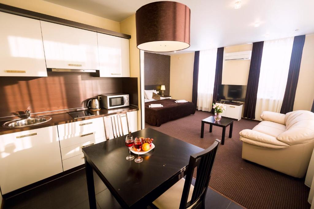 a kitchen and a living room with a table in a room at History Hotel in Vologda